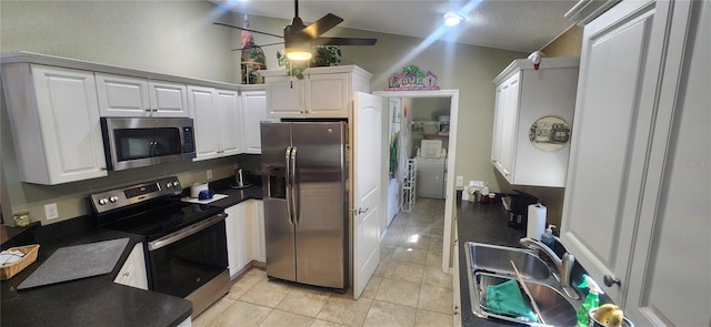 kitchen with stainless steel appliances, ceiling fan, light tile patterned flooring, sink, and white cabinetry