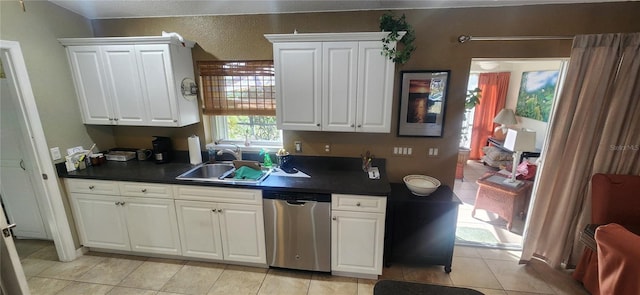 kitchen with light tile patterned flooring, white cabinetry, dishwasher, and sink