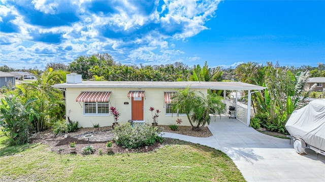 view of front of house with a front yard and a carport