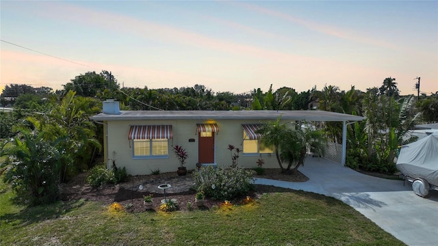 ranch-style home with a carport and a yard