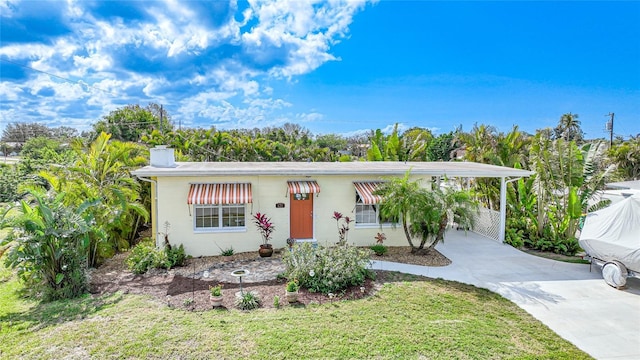 view of front of house featuring a carport and a front yard