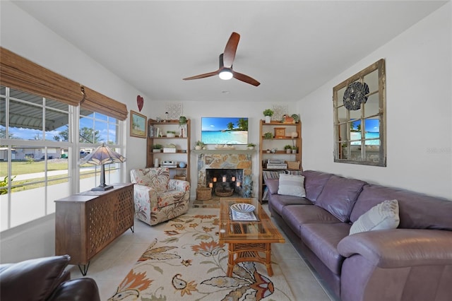 living room with light tile patterned floors, a fireplace, and ceiling fan