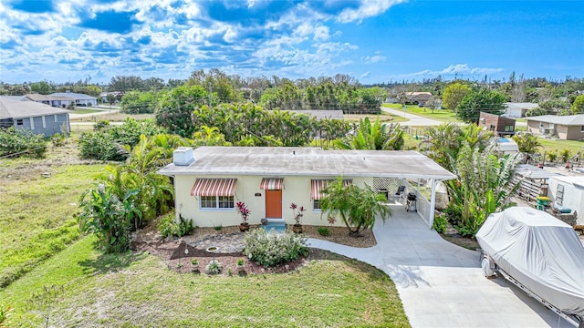 ranch-style home featuring a front lawn and a carport