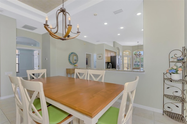 dining space with sink, light tile patterned floors, and a notable chandelier