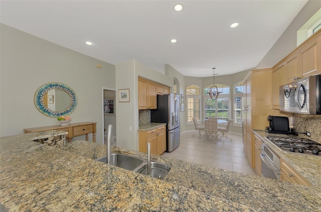 kitchen featuring pendant lighting, sink, appliances with stainless steel finishes, backsplash, and light brown cabinetry