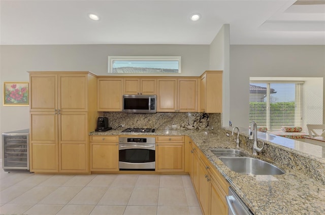 kitchen featuring sink, light tile patterned floors, stainless steel appliances, light brown cabinetry, and beverage cooler