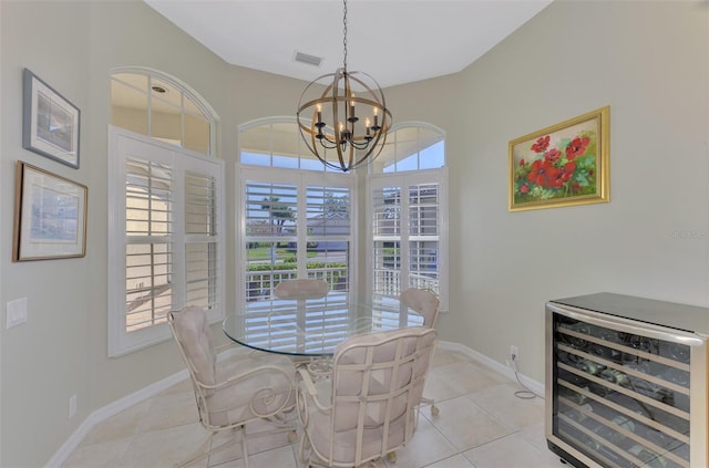 dining area featuring wine cooler, a healthy amount of sunlight, light tile patterned floors, and a notable chandelier