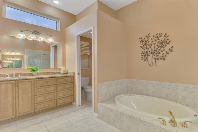 bathroom with vanity, tile patterned flooring, tiled bath, and toilet