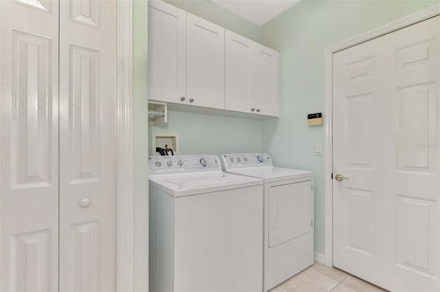 washroom featuring cabinets, light tile patterned floors, and washing machine and clothes dryer