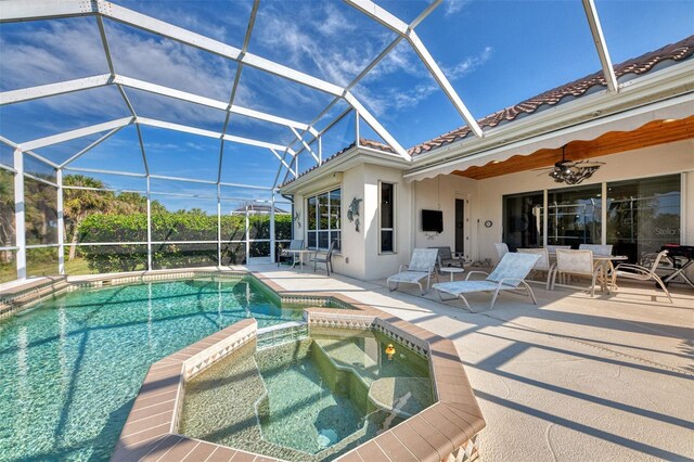 view of pool with a patio area, an in ground hot tub, ceiling fan, and glass enclosure