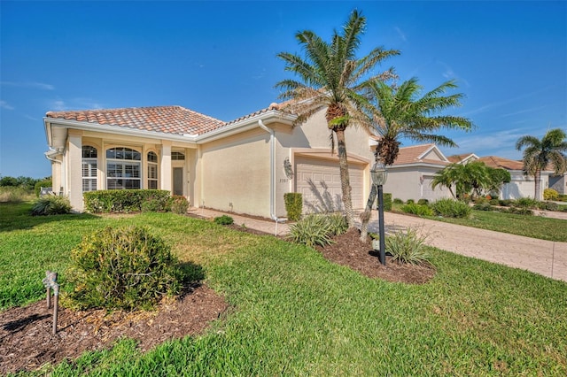 mediterranean / spanish-style house featuring a garage and a front yard