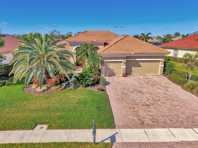 mediterranean / spanish-style house with a garage and a front lawn