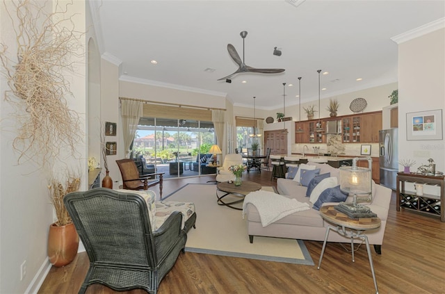 living room with hardwood / wood-style flooring, ceiling fan, ornamental molding, and sink