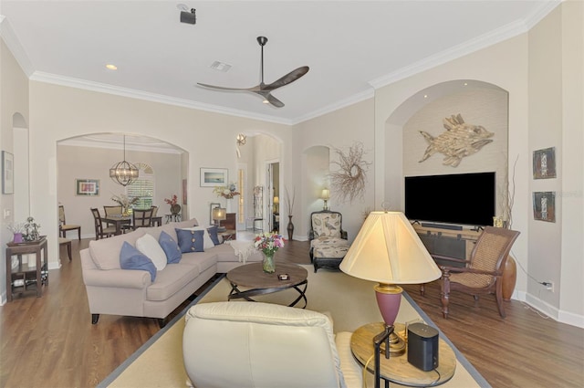 living room with crown molding, ceiling fan with notable chandelier, and hardwood / wood-style floors