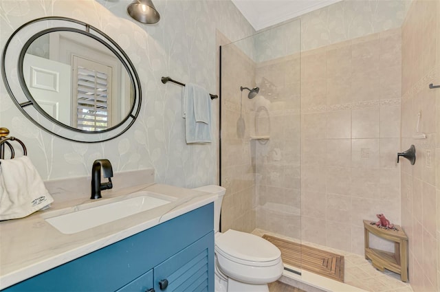 bathroom with vanity, a tile shower, crown molding, and toilet