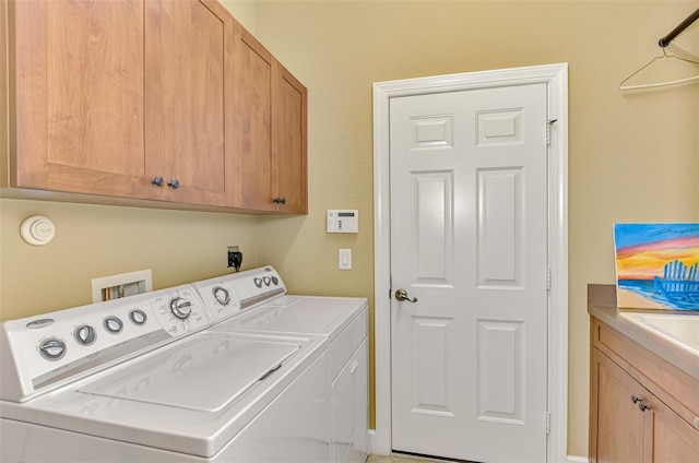 laundry area featuring separate washer and dryer and cabinets