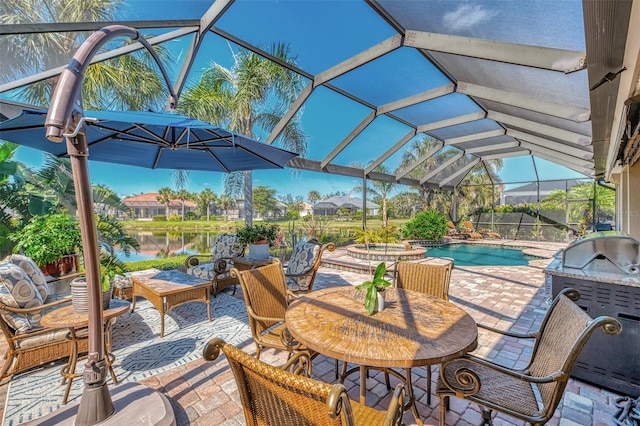 view of patio / terrace featuring a swimming pool with hot tub, a water view, an outdoor kitchen, and glass enclosure