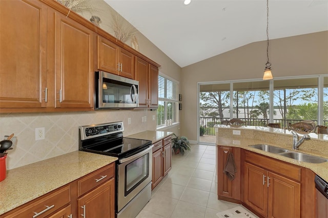 kitchen featuring light stone counters, sink, hanging light fixtures, and appliances with stainless steel finishes