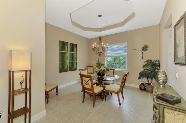 dining room featuring light tile patterned flooring, a raised ceiling, and a notable chandelier