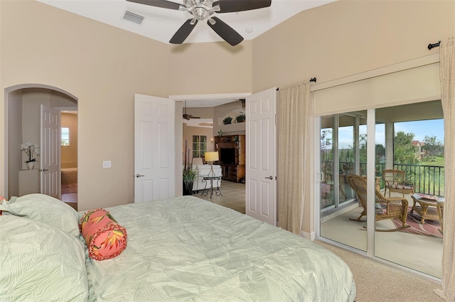 bedroom with a high ceiling, access to outside, and ceiling fan