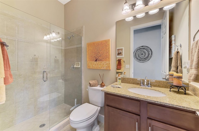 bathroom with vanity, toilet, and a shower with shower door