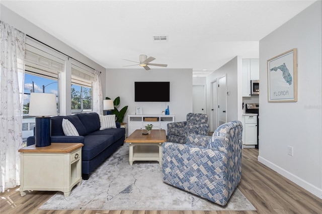 living room with ceiling fan and wood-type flooring