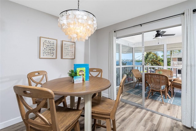 dining area featuring ceiling fan with notable chandelier and hardwood / wood-style floors