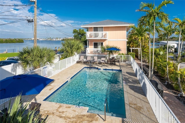 view of swimming pool featuring a patio and a water view