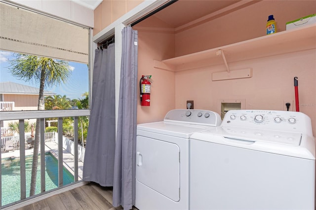 clothes washing area featuring separate washer and dryer and light hardwood / wood-style floors