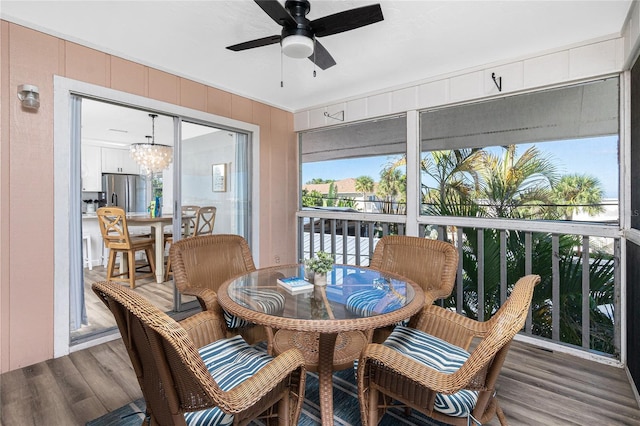 sunroom / solarium with ceiling fan with notable chandelier