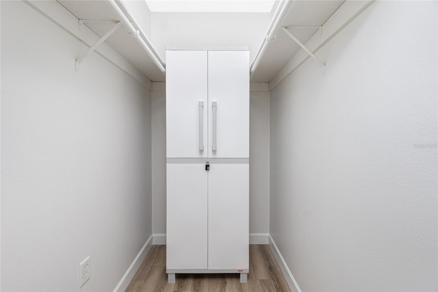 walk in closet with light wood-type flooring