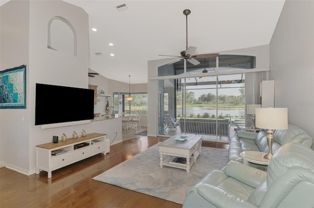 living room with wood-type flooring, high vaulted ceiling, and ceiling fan