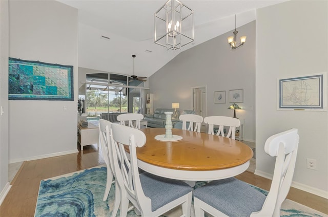 dining room featuring ceiling fan, hardwood / wood-style floors, and high vaulted ceiling