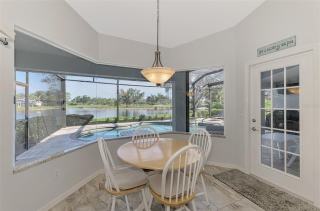 dining space featuring vaulted ceiling, a water view, and a wealth of natural light