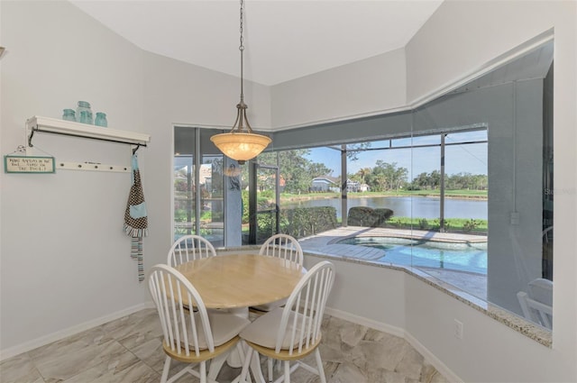 dining room with a water view and lofted ceiling