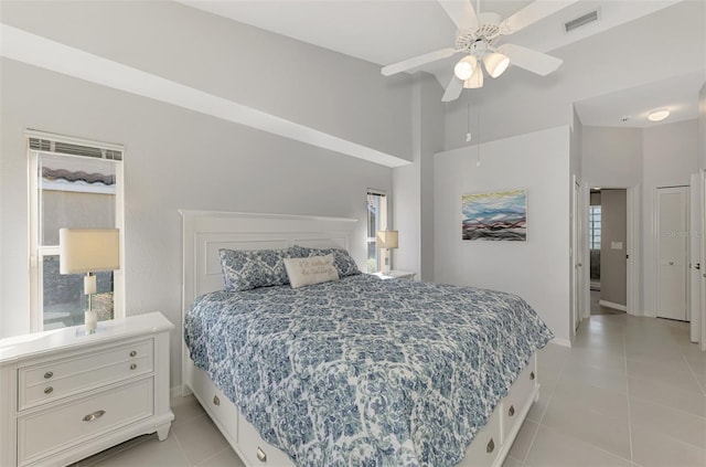 bedroom with light tile patterned flooring, a towering ceiling, and ceiling fan