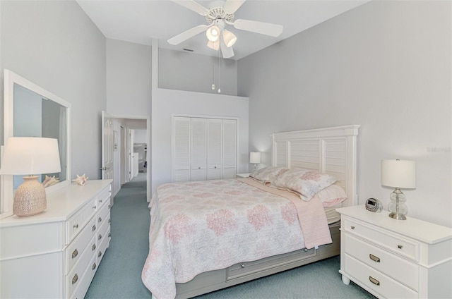 carpeted bedroom with high vaulted ceiling, ceiling fan, and a closet