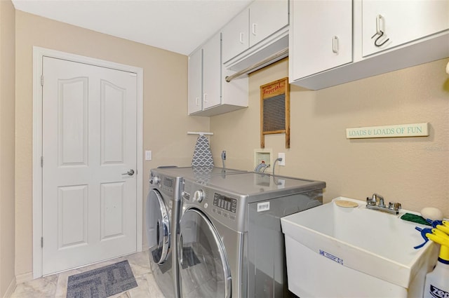 laundry area featuring independent washer and dryer, cabinets, and sink