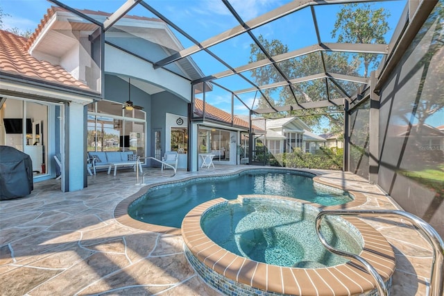 view of pool featuring outdoor lounge area, an in ground hot tub, a lanai, ceiling fan, and a patio area