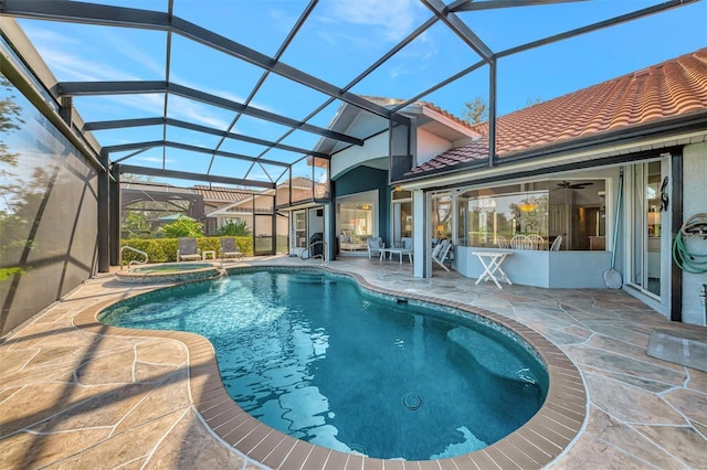 view of swimming pool featuring an in ground hot tub, a patio, ceiling fan, and glass enclosure