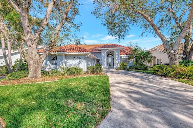 mediterranean / spanish house featuring a front lawn