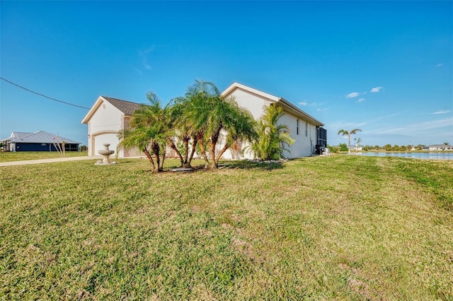 view of property exterior with a garage, a water view, and a yard