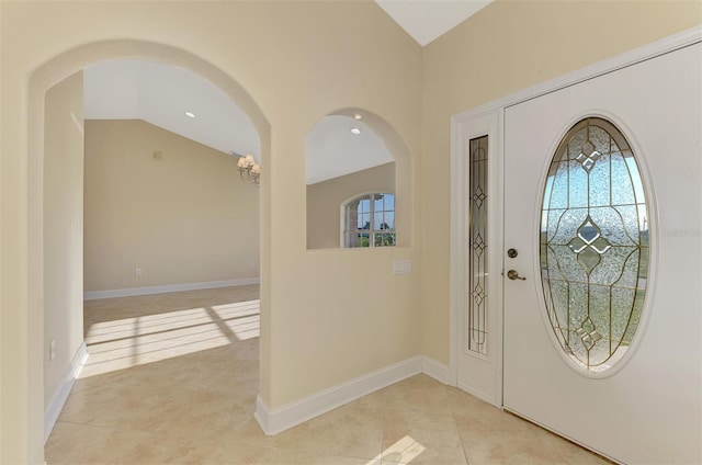 tiled foyer featuring a wealth of natural light and vaulted ceiling