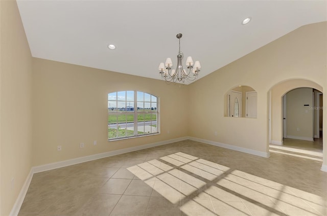 tiled empty room with lofted ceiling and a notable chandelier