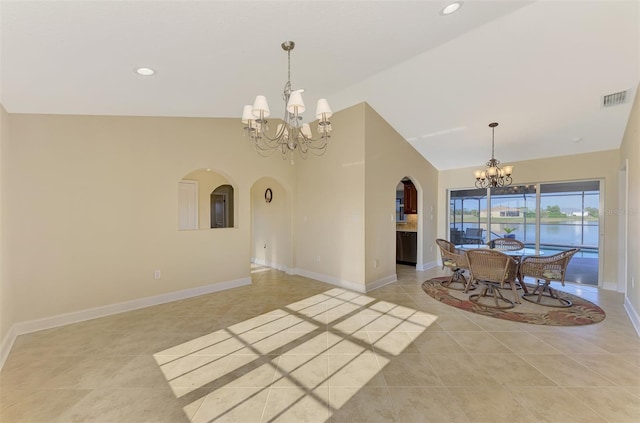 dining space featuring arched walkways, a notable chandelier, visible vents, vaulted ceiling, and baseboards