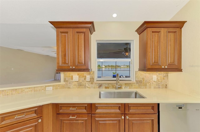 kitchen featuring dishwashing machine, sink, tasteful backsplash, and ceiling fan