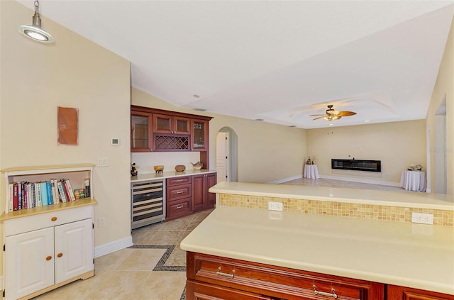 kitchen featuring light tile patterned floors, ceiling fan, decorative backsplash, vaulted ceiling, and beverage cooler