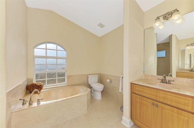 bathroom with vaulted ceiling, vanity, a relaxing tiled tub, toilet, and tile patterned floors