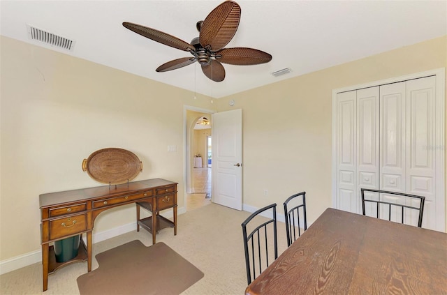 carpeted dining area with ceiling fan