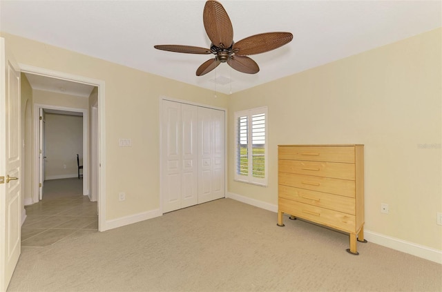 unfurnished bedroom featuring light carpet, ceiling fan, and a closet